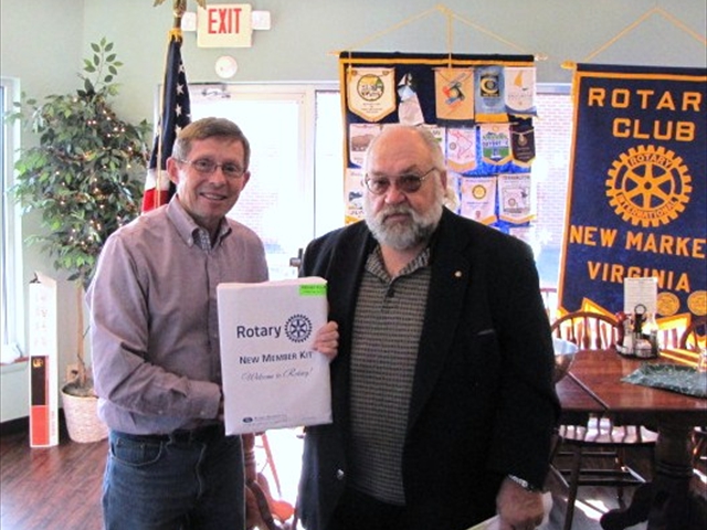 Jim Douglas welcomes Rotarian Charles Day into the Club.